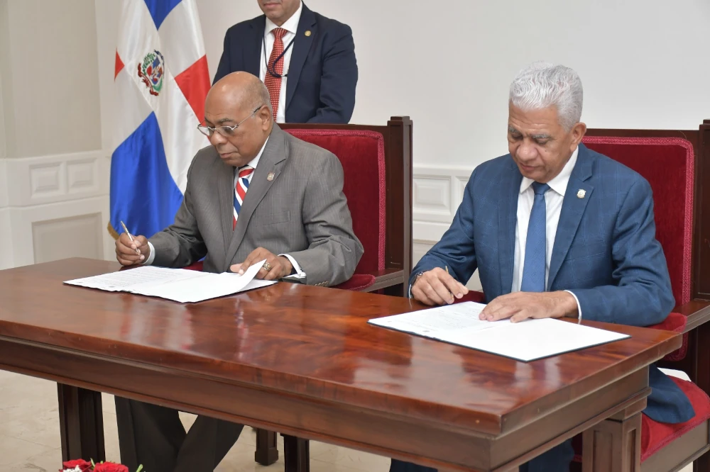 Presidentes del Senado de la República, Ricardo De los Santos, y del Tribunal Constitucional magistrado Milton Ray Guevara, firmando el acuerdo.