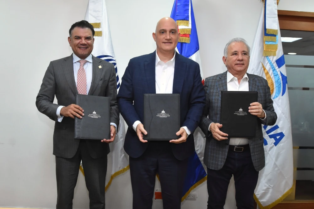 Gerente Andrés Vander Horst, Ministro Pável Isa Contreras, y el senador Antonio Taveras Guzmán sostienen el contrato.