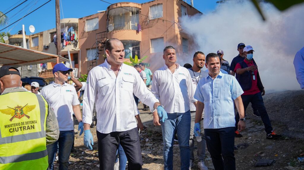 hombres limpiando y fumigando la zona