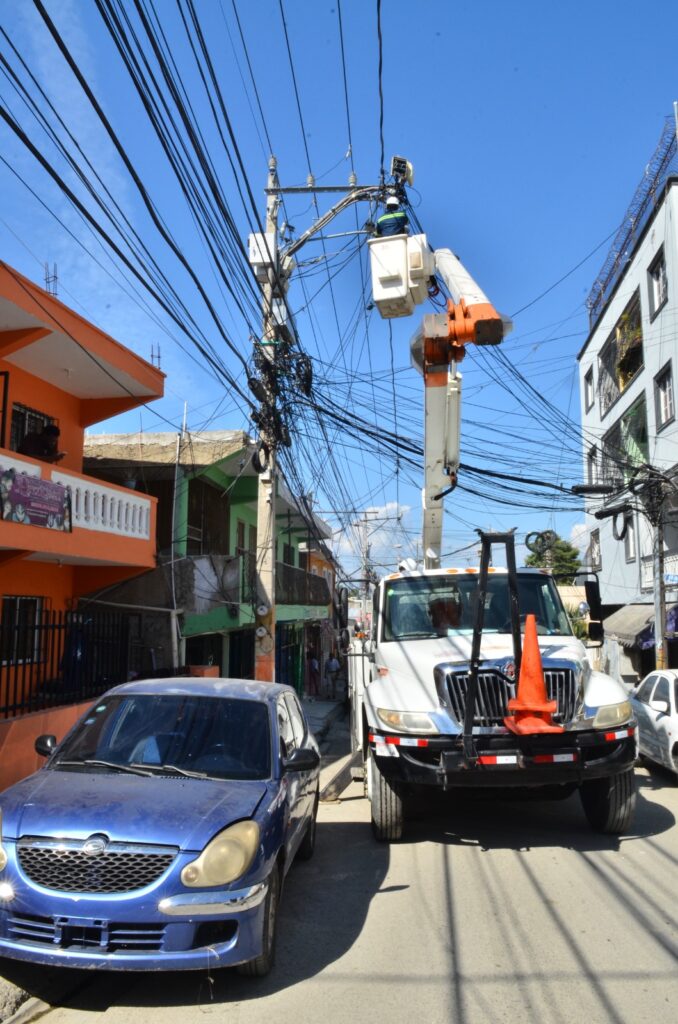 empleados de edesur colocan bombillas en las calles del barrio Enriquillo de herrera