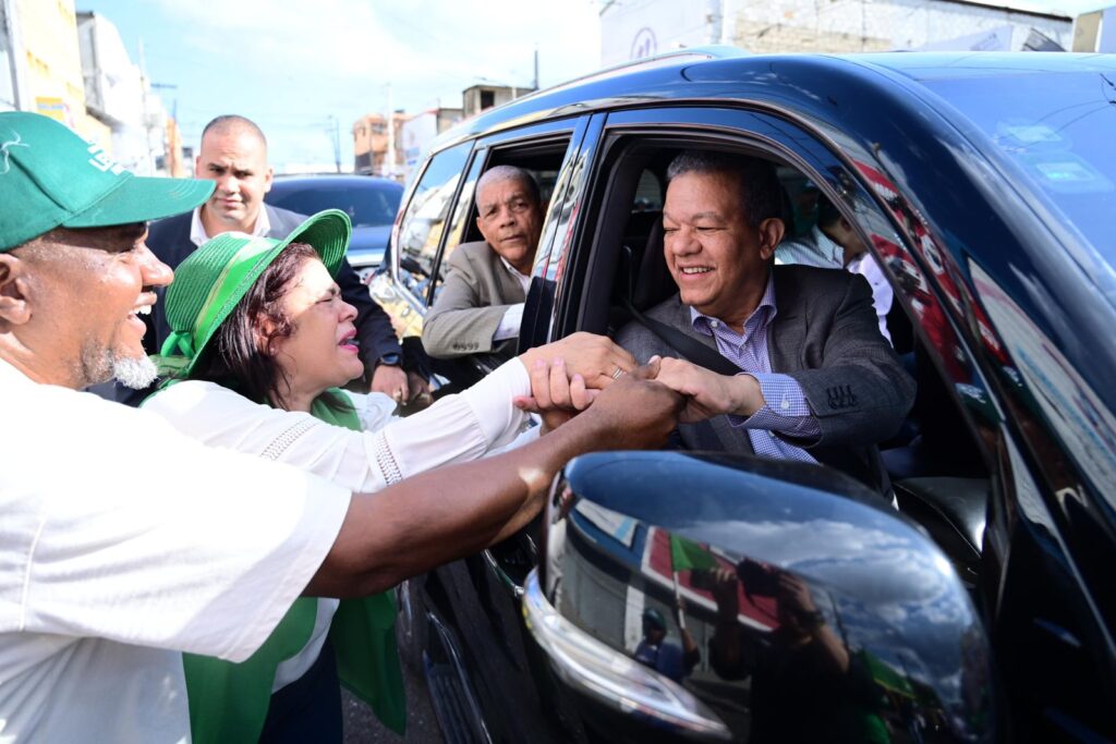 Leonel Fernández, saludando desde su vehiculo