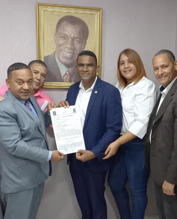 Junior Muñoz muestra su certificado como el primer candidato a Diputado por Santo Domingo Norte. 