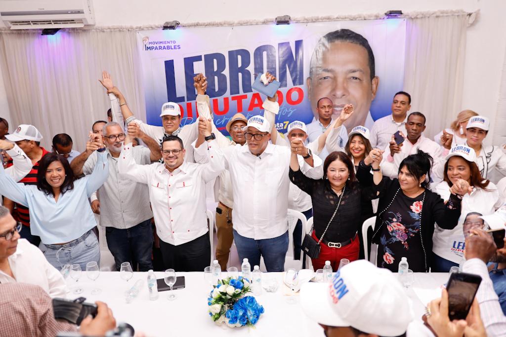 El dirigente político, Evinson Lebron y varios dirigentes levantando las manos 