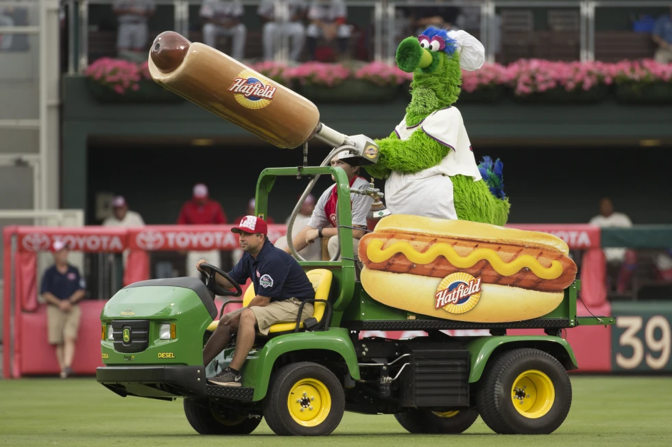 ARCHIVO - The Phillie Phanatic sale con su lanzador de hot dog durante la quinta entrada de un juego de béisbol entre los Bravos de Atlanta y los Filis de Filadelfia, el lunes 4 de julio de 2016, en Filadelfia. Durante más de un cuarto de siglo, los fanáticos de los Filis pensaron que la noche de hot dogs a un dólar era la mejor promoción en el estadio, pero ahora el equipo decidió que fue la peor. (Foto AP/Chris Szagola, archivo)

